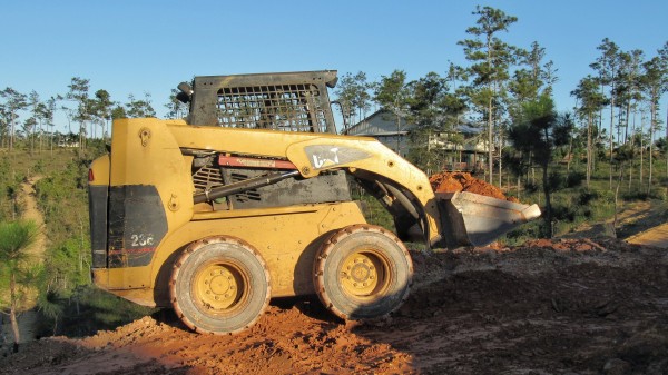 A skid steer at work moving dirt